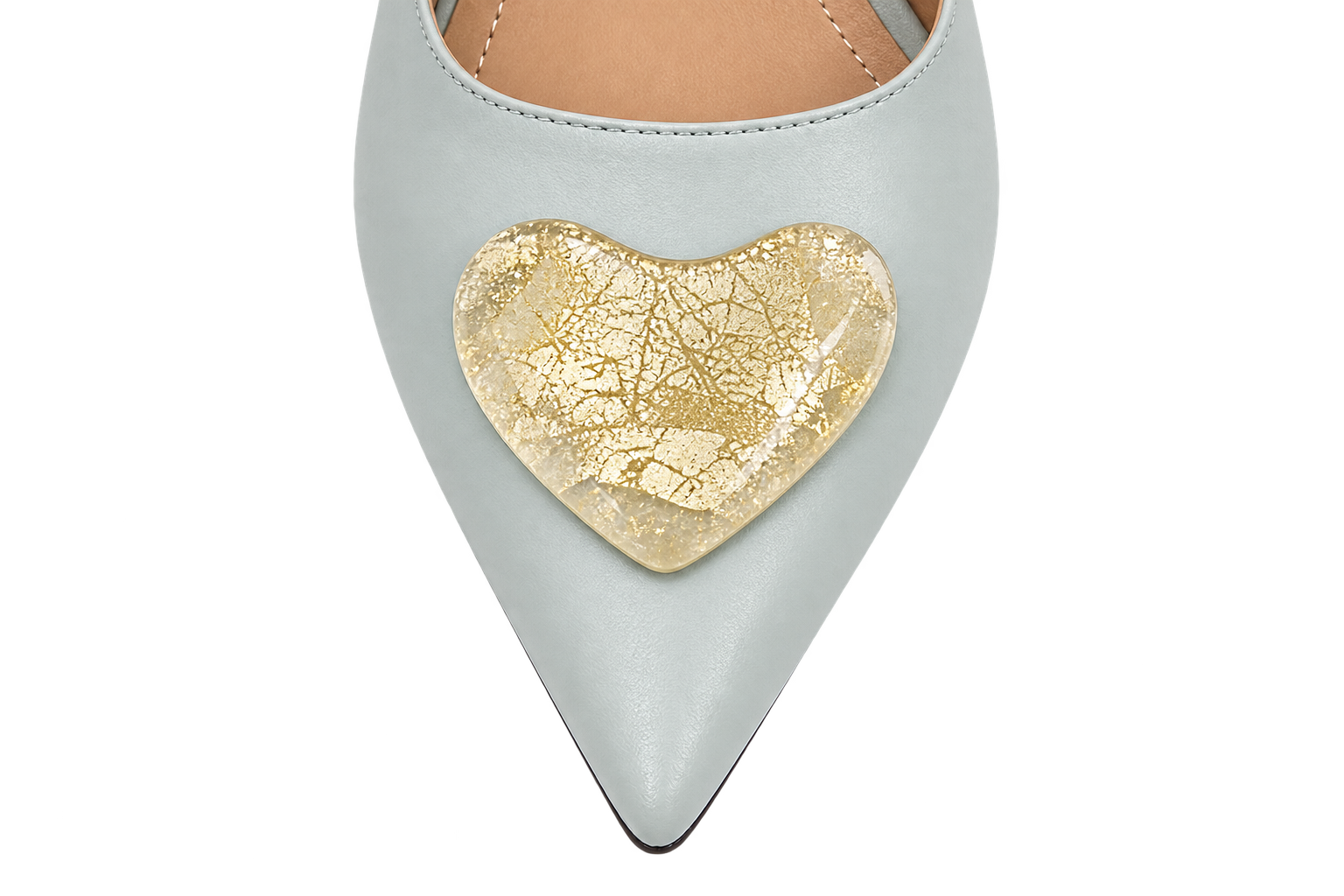 A close-up of a light blue pointed-toe shoe featuring a large, textured gold heart-shaped embellishment on the toe box, set against a plain white background.
