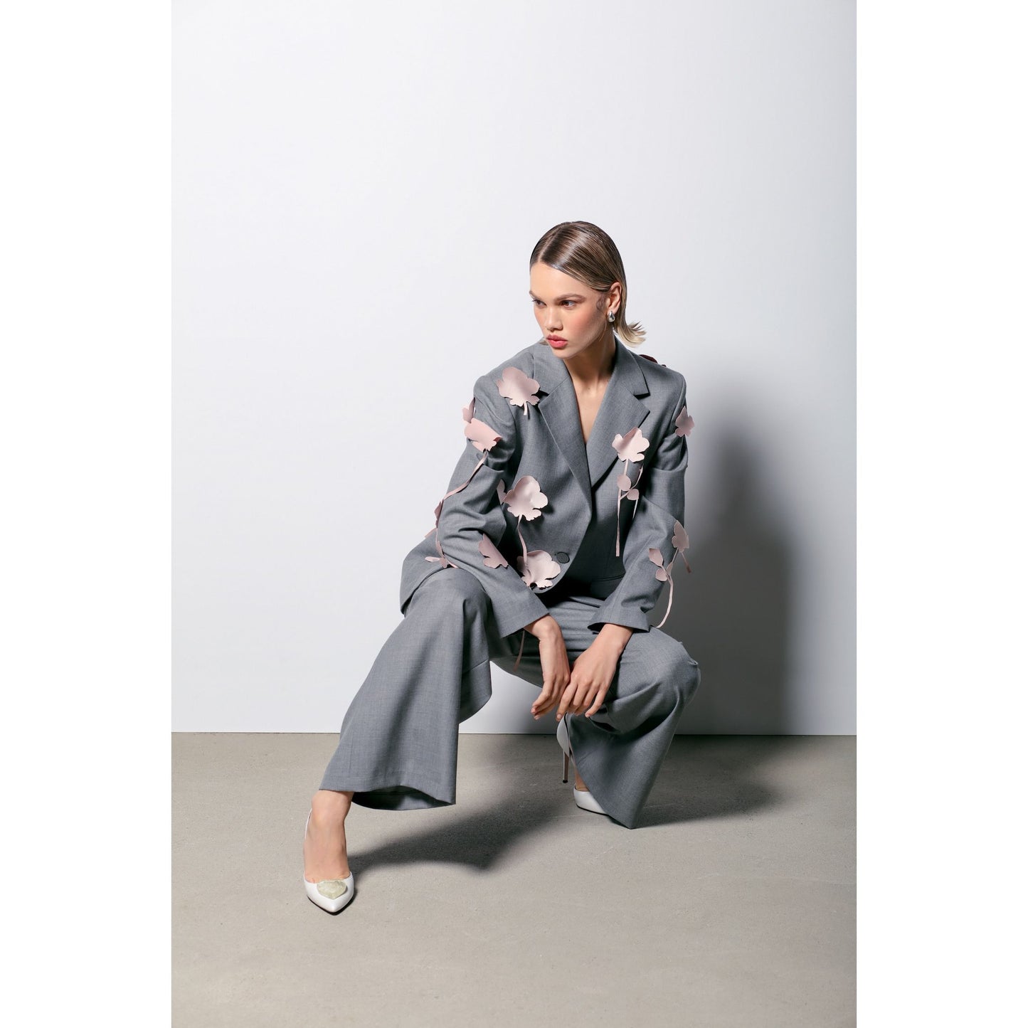 white ivory leather stilettos with gold hearts with grey suit