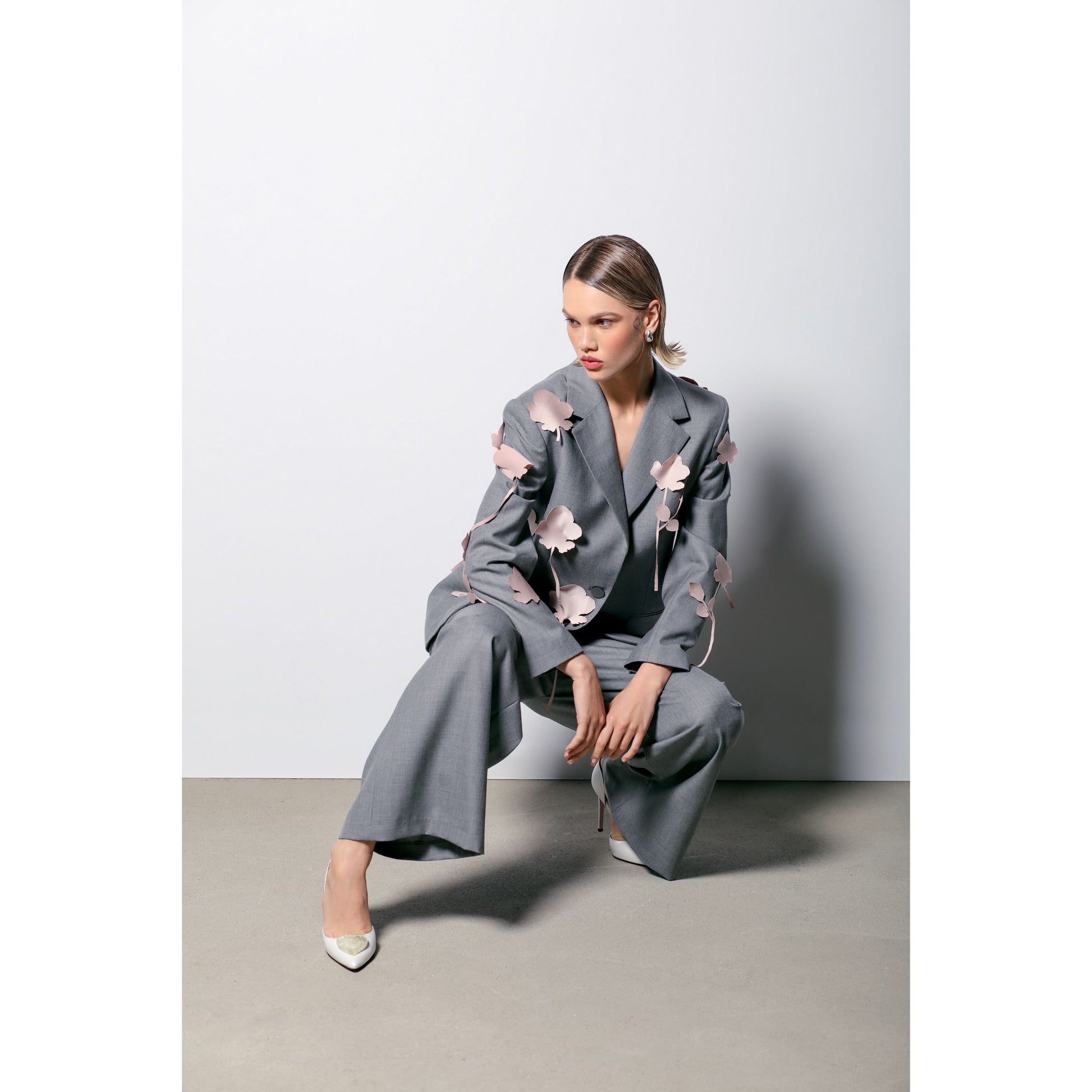 white ivory leather stilettos with gold hearts with grey suit